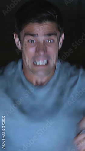 Man Watching Tv at Night with a Concerned Expression