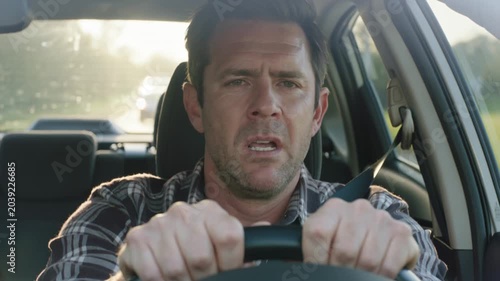 Stressed man driving car with panicked expression during commute