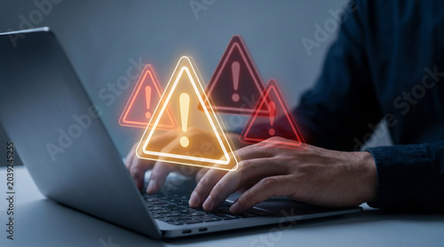 Warning alert triangle icons glowing over laptop keyboard representing system error notification