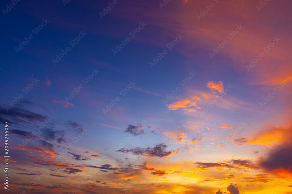 Fototapeta premium Beautiful dramatic sunset sky with vibrant clouds and gradient colors,A breathtaking panoramic view of a dramatic sunset sky filled with vibrant orange, yellow, and blue clouds, perfect for nature.