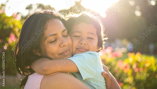 happy mother hugging little child outdoors.