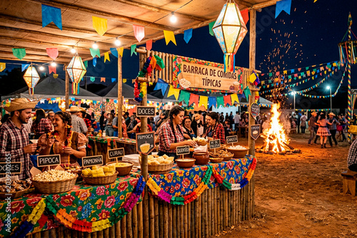 Festa Junina celebration with traditional food stall and bonfire in Brazil