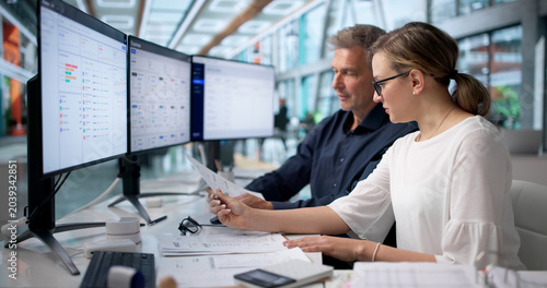 Fotografie Two Accountants Review Receipts And Spreadsheets Together