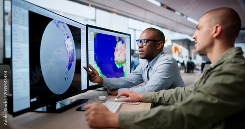 Two Meteorologists Use Computers