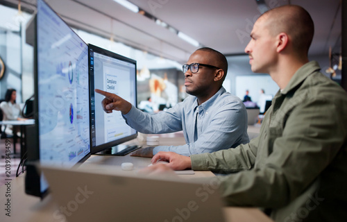 Canvas Print Two Men Analyze Compliance Data Together