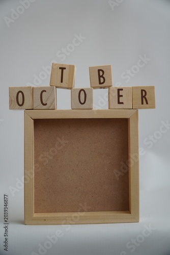 Wooden Letter Blocks Spelling The Month Of October Above An Empty Square Frame