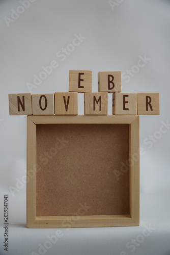 Wooden Alphabet Blocks Spelling Out the Month of November Above a Simple Wooden Frame for Text