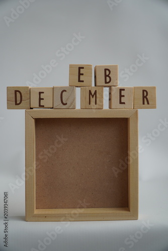 Simple Wooden Block Lettering Spelling December Above Empty Square Frame