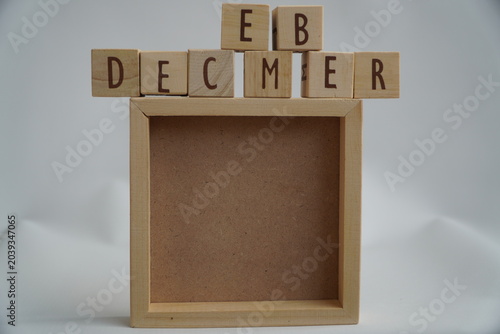 Wooden Alphabet Blocks Spelling Out December Above Empty Natural Wood Frame