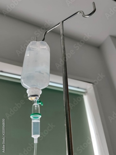 Iv drip running with saline close up in a hospital.