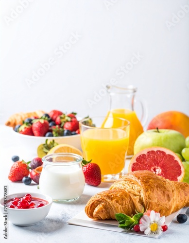 A delicious breakfast spread with fresh fruits and pastries on a table indoors