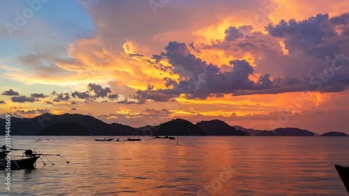Traditional wooden boats float on calm water during a golden sunset