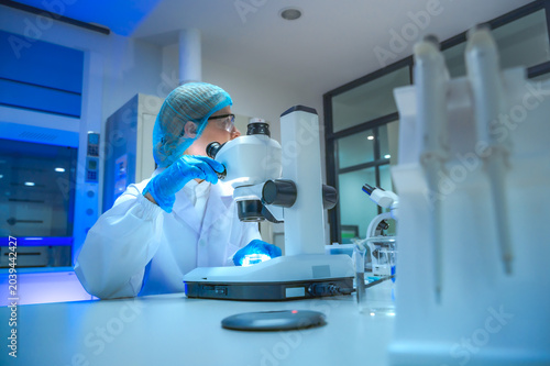 Fotografia Serious medical scientist concentrating on analyzing dangerous disease samples w