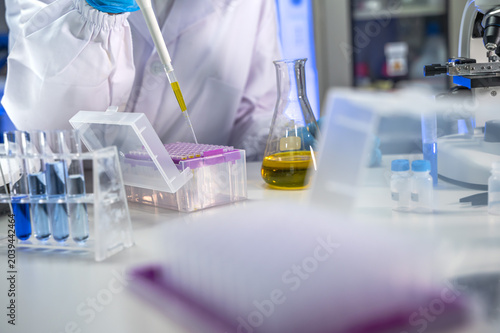 Bild auf Leinwand Unknown scientist in white lab coat intently conducting research and analyzing s