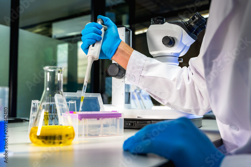 Fotografía Unknown scientist in white lab coat intently conducting research and analyzing s