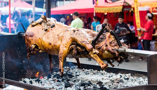 Roasted pig on a spit over charcoal