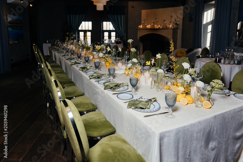 Valokuva Tables with green napkins, glasses, flowers, and chairs