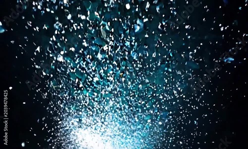 a shower of blue and silver confetti cascading downwards, sparkling like tiny stars