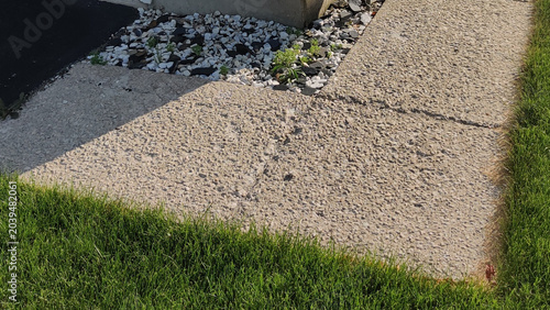 Foto Exposed Aggregate Concrete Sidewalk Along Residential Home