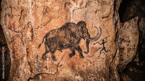 Ancient Cave Painting Depicting a Mammoth and Human Figures in Prehistoric Times.