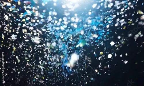a shower of blue and silver confetti cascading downwards, sparkling like tiny stars