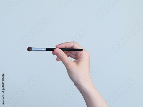 メイクブラシを持つ手元