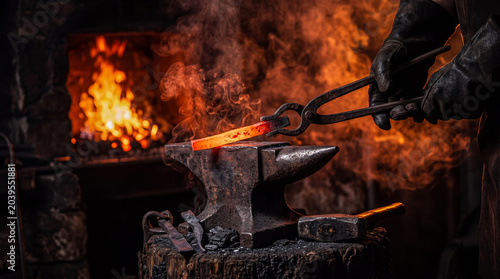 Foto Blacksmith's gloved hands working with tongs to shape a glowing hot metal bar on an old anvil in a forge