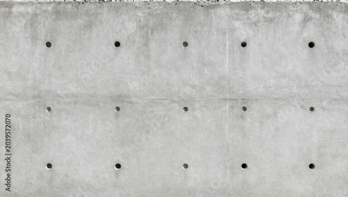 Concrete wall with drilled holes in a construction site at midday