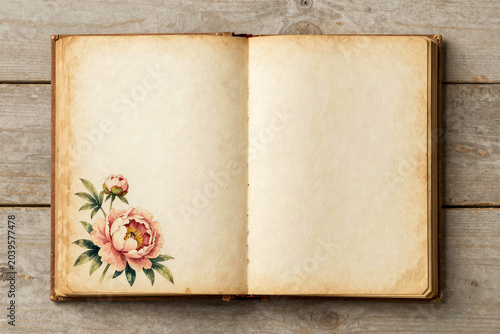 Open vintage book with blank aged pages and watercolor peony flower illustration on rustic wooden background