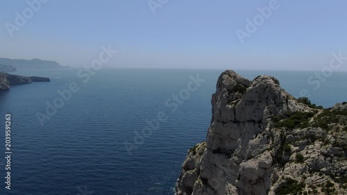 passage à basse altitude sur la crête de la calanque de Sormiou au sud de Marseille, en été, avec des bateaux dans la baie