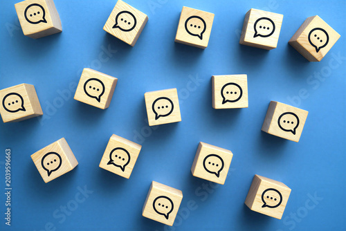 Wooden blocks with speech bubble icons on blue background