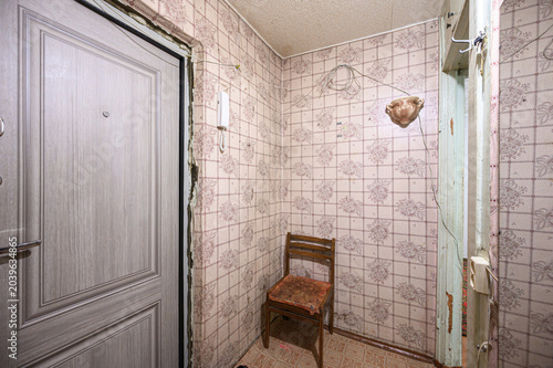 Canvas Print cramped vintage hallway with faded floral wallpaper, a worn wooden chair, expose