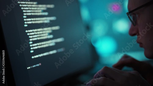 Programmer wearing glasses actively writes code on laptop, leveraging artificial intelligence tools to streamline software development, enhancing efficiency with each keystroke in the coding process