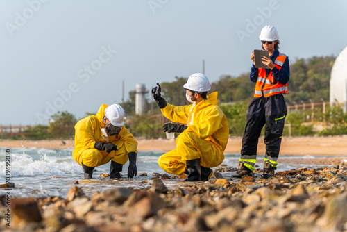 Vászonkép Hazmat workers in yellow suits test ocean water samples