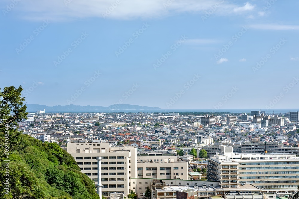 Obraz premium 米子城跡の山頂から弓ヶ浜半島と日本海を一望する広大な都市景観/Vast Urban Landscape Looking Out Over the Yumigahama Peninsula and the Sea of Japan from the Summit of Yonago Castle Ruins