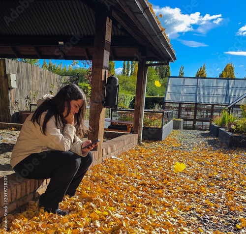 Cuadro en lienzo young woman looking at her cell phone in a beatiful autumn landscape