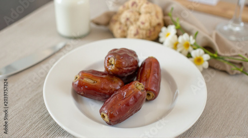 Delicious dates on a plate with milk and cookies nearby