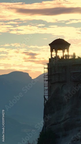 Monasteries of Meteora, Thessaly Greece. Time lapse of clouds moving across evening sky over holy Varlaam monastery on rock formation. Vertical video