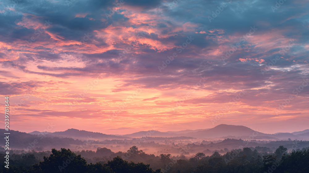 Fototapeta premium Vibrant Sunset Over Rolling Hills and Dense Forest with Colorful Sky