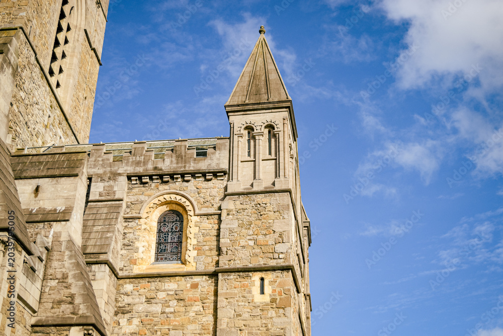 Fototapeta premium Christ Church Cathedral stone towers under a blue sky in Dublin, Ireland