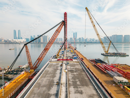 Tableau sur toile Bridge dismantling progress over river with large cranes and heavy equipment ope