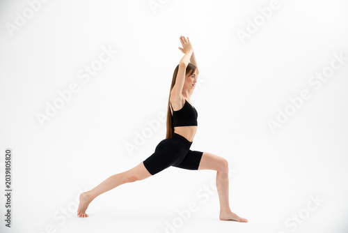 Beautiful brunette fitness woman doing yoga on a white background