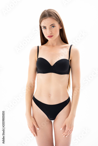 Beautiful girl in black lingerie posing on a white Isolated background