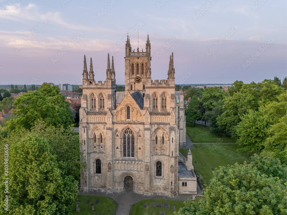 Obraz premium Selby Abbey in Selby, North Yorkshire, England, aerial view of the historic abbey, town centre rooftops, streets and medieval architecture.