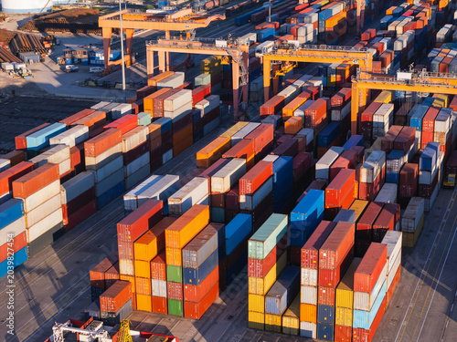 Cargo containers are organized at a shipping port. Cranes move containers for global trade and transport operations.