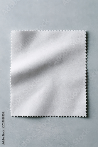 Minimalist White Microfiber Cloth with Serrated Edges on Textured Gray Background for Cleaning Concepts