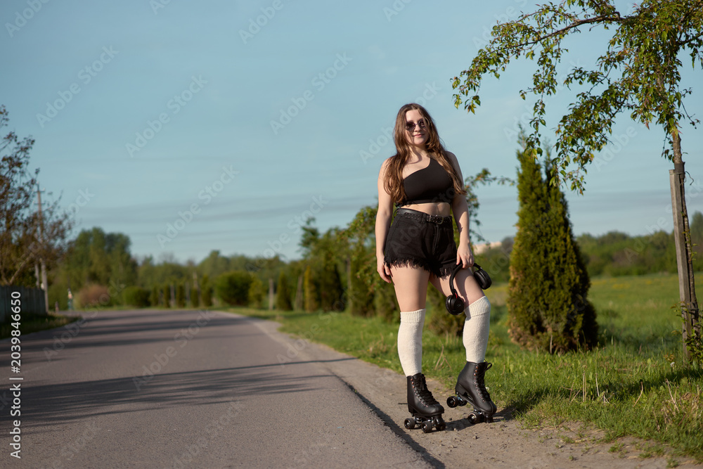 Fototapeta premium Roller skating adventure on a sunny afternoon by the tranquil path lined with greenery