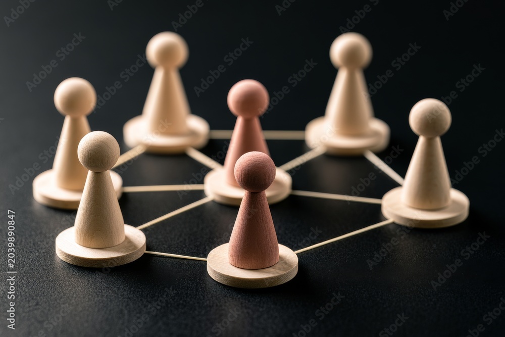 Obraz premium Wooden game pieces connect in a circle on a dark surface showing a network of relationships among eight players