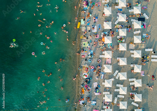 Foto Aerial view of a vibrant beach filled with bathers enjoying warm water and sun u