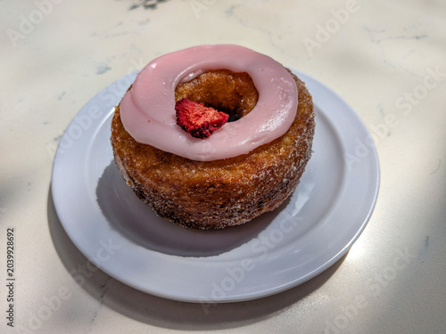 Croissant style donut with pink frosting
